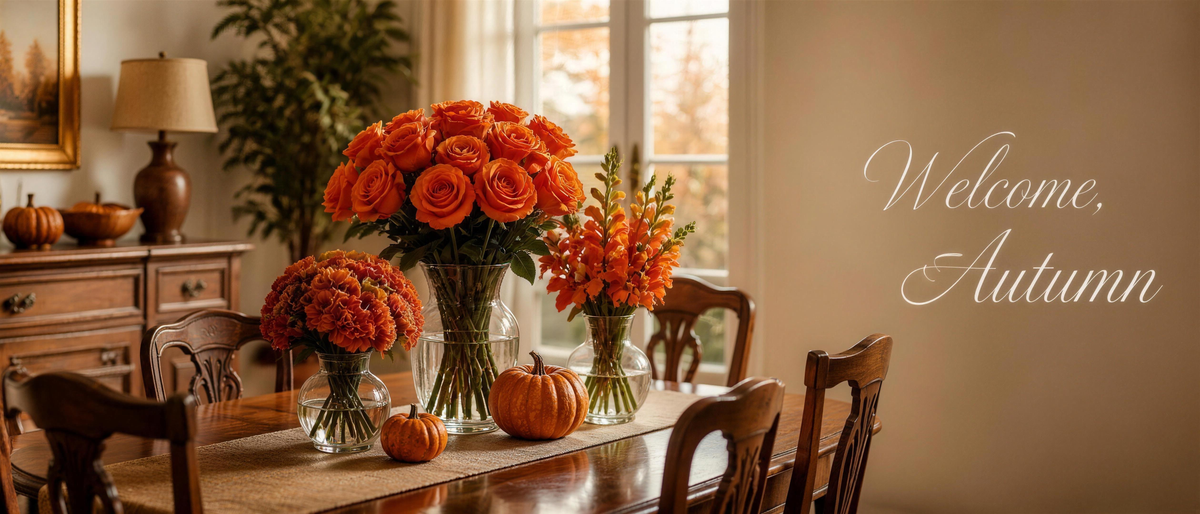 Welcome Autumn - cozy dining room with orange roses, carnations, antirrhinum and pumpkins on a wooden table